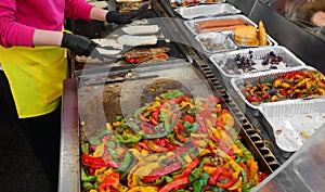 sizzling hot griddle on a street food truck counter is preparing mouth-watering sandwiches filled with rilled sausage and roasted