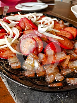 Sizzling Hotdog and onions, a popular Filipino appetizers or pulutan served in a restaurant or bar