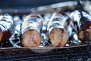 Sizzling sausage on a campfire grill during a fun barbecue.