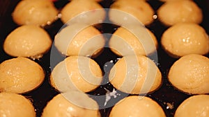 Sizzling Takoyaki, a ball-shaped Japanese snack being cooked on a pan