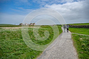 Skaill House at Orkney Island, view from the distance with walking path in front and lots of tourist walking to the building,