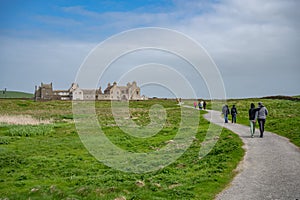Skaill House at Orkney Island, view from the distance with walking path in front and lots of tourist walking to the building,