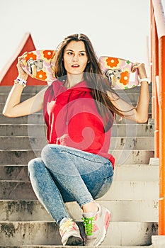 Skate girl on stairs with skateboard.