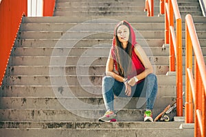 Skate girl on stairs with skateboard.