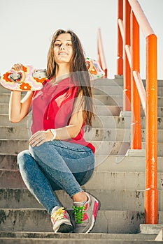 Skate girl on stairs with skateboard.