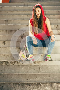 Skate girl on stairs with skateboard.