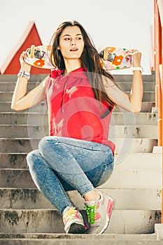 Skate girl on stairs with skateboard.