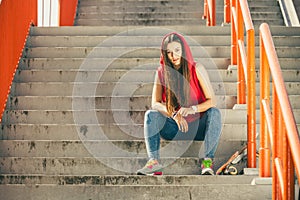 Skate girl on stairs with skateboard.