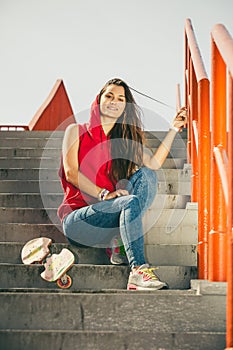 Skate girl on stairs with skateboard.