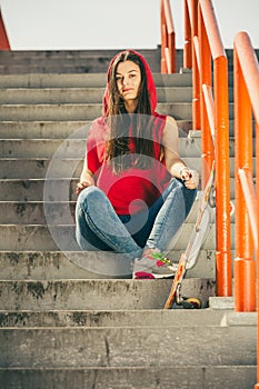 Skate girl on stairs with skateboard.