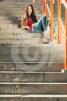 Skate girl on stairs with skateboard.