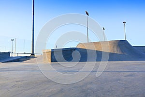 Skate park generic concrete ramps outside with blue sky photo