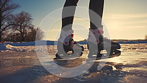 skate on the river. child playing on the river in winter. close-up legs child skating on ice in winter on the river