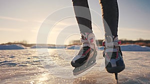 skate on the river. child playing on the river in winter. close-up legs child skating on ice in winter on the river