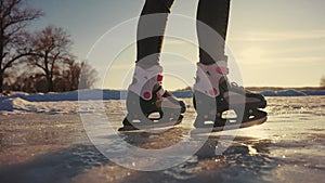 skate on the river. child playing on the river in winter. close-up legs child skating on ice in winter on the river