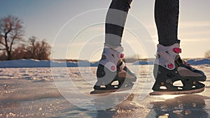 skate on the river. child playing on the river in winter. close-up legs child skating on ice in winter on the river