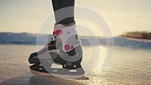 skate on the river. child playing on the river in winter. lifestyle close-up legs child skating on ice in winter on the