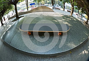 Skateboard on city skatepark ramp