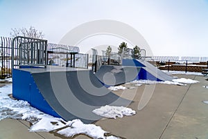 Skateboard ramps and melting snow on a skate park