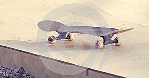 Skateboard standing on half pipe ramp at skatepark.