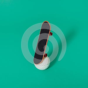 Skateboard on a white golf ball. .Green background