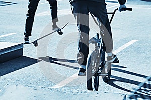 Skateboarder and bicycler. Blue toning