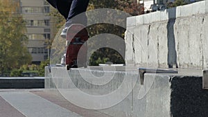 Skateboarder does grind trick 5-0 on street ledge, architectural monument