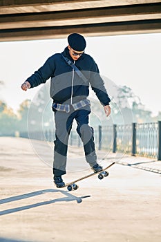 Skateboarder does ollie trick on street urban background