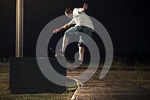 Skateboarder doing a Frontside Boardslide trick at night