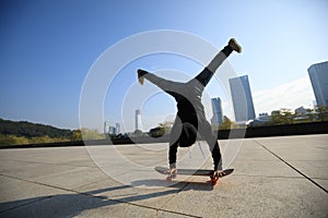 Skateboarder doing a hand on skateboard