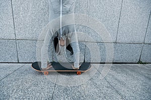 Skateboarder doing a handstand on skateboard against wall