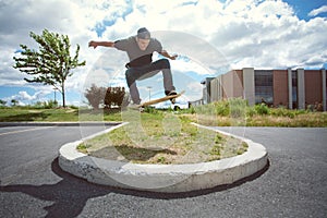 Skateboarder doing a Ollie Over a Grass Section