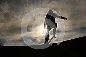 Skateboarder doing ollie in sunset