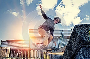 Skateboarder doing a skateboard jumping trick at sunrise city