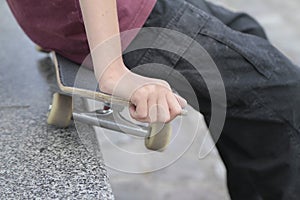 Skateboarder with a hand on his skateboard