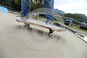 Skateboarder legs practice ollie at skatepark ramp