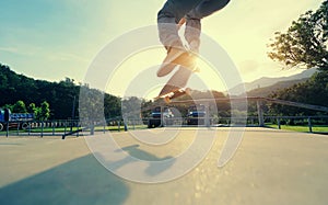 Skateboarder legs practice ollie at skatepark ramp