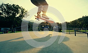 Skateboarder legs practice ollie at skatepark ramp photo
