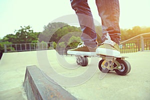 Skateboarder legs riding on freeline at skatepark photo