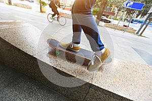 Skateboarder legs riding skateboard at city skatepark