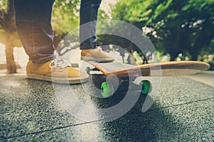 Skateboarder legs riding skateboard at city skatepark