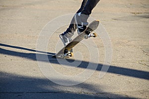 Skateboarder legs riding skateboard at skatepark