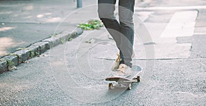 Skateboarder legs riding skateboard on the street