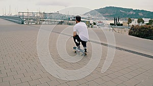 Skateboarder rides a skateboard in the modern city terrace.