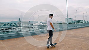 Skateboarder rides a skateboard in the modern city terrace.