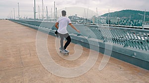 Skateboarder rides a skateboard in the modern city terrace.