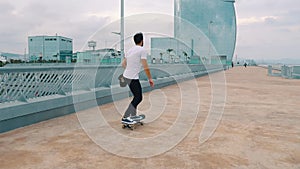 Skateboarder rides a skateboard in the modern city terrace.