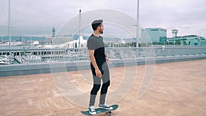 Skateboarder rides a skateboard in the modern city terrace.