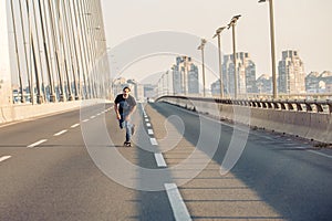 Skateboarder riding a skate over a city road bridge. Free ride s