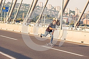 Skateboarder riding a skate over a city road bridge. Free ride s